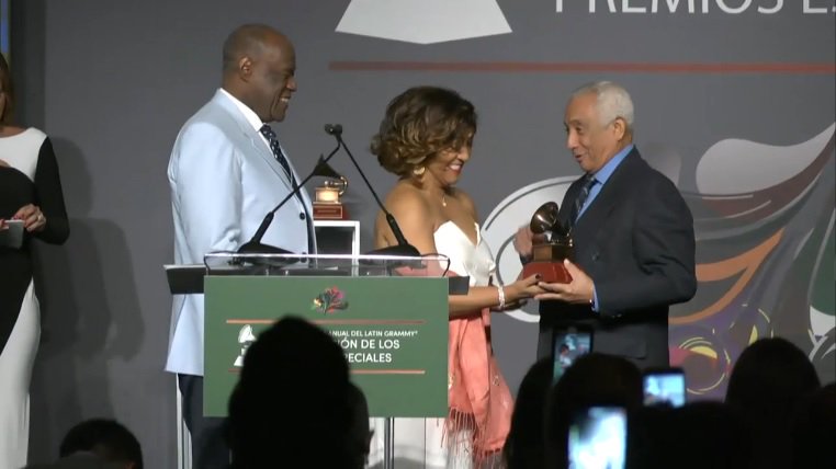 Rafael Solano mientras recibe de manos de los populares artistas Milly Quezada y Johnny Ventura, el galardón otorgado por la Academia Latina de la Grabación.